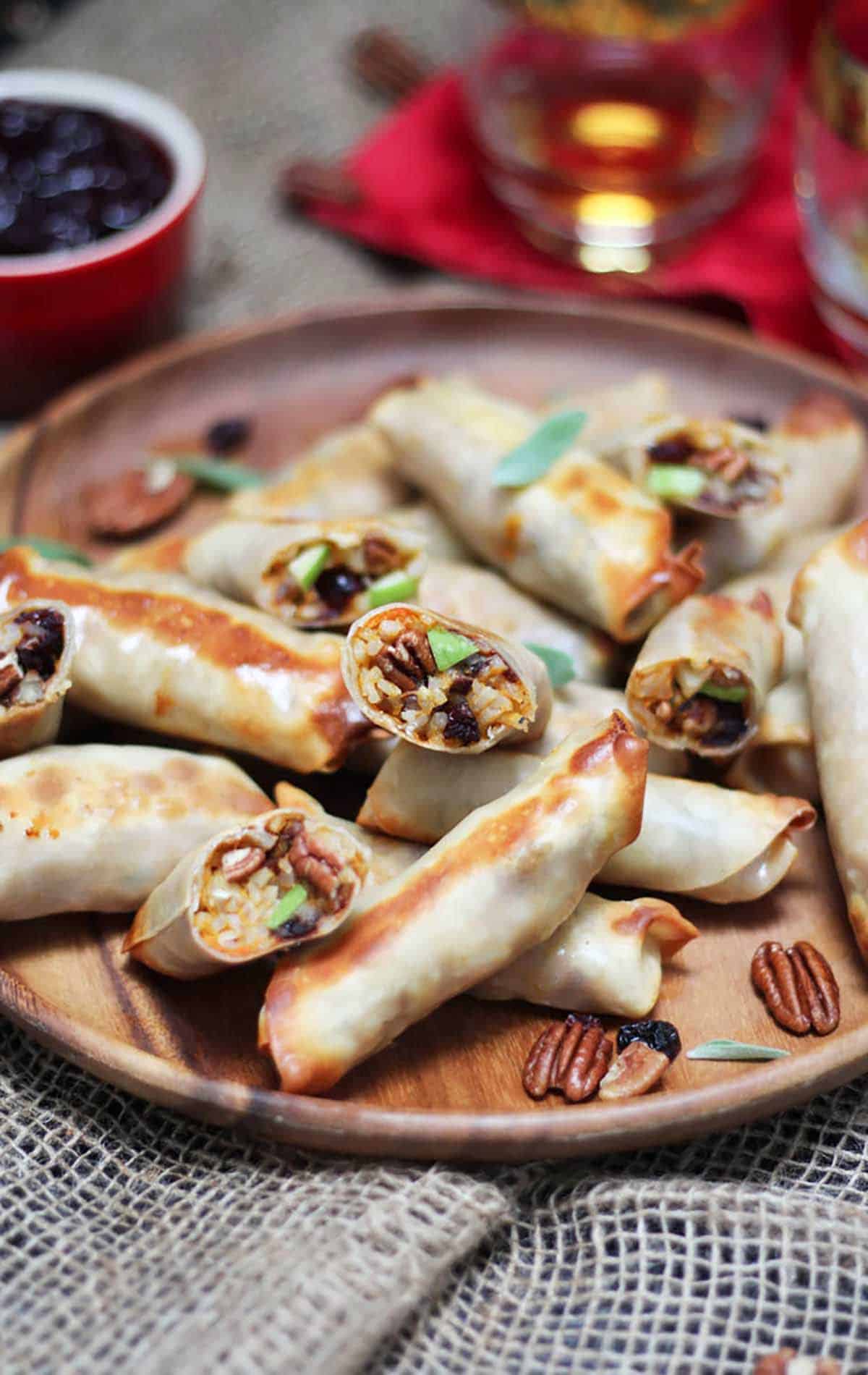 Several baked spring rolls on a wooden plate. 