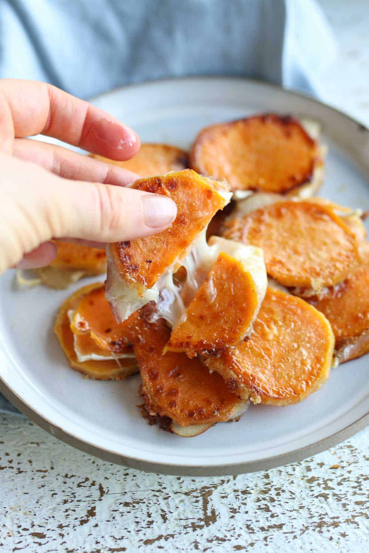 Photo showing the cheese pull from a grilled cheese bite made with sweet potatoes.