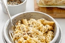 A bowl of baked vegan mac and cheese in a bowl with a fork inside of it.
