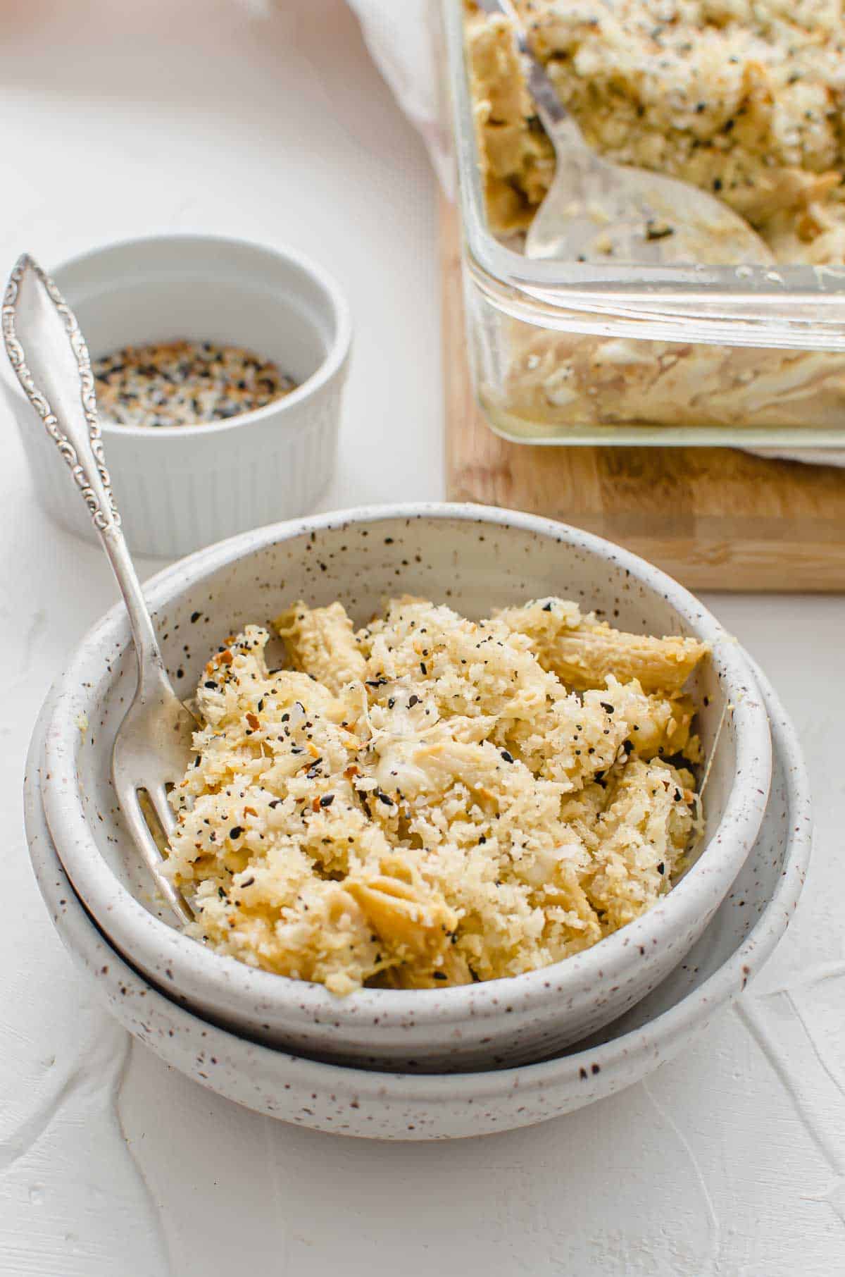 A bowl of baked vegan mac and cheese in a bowl with a fork inside of it.