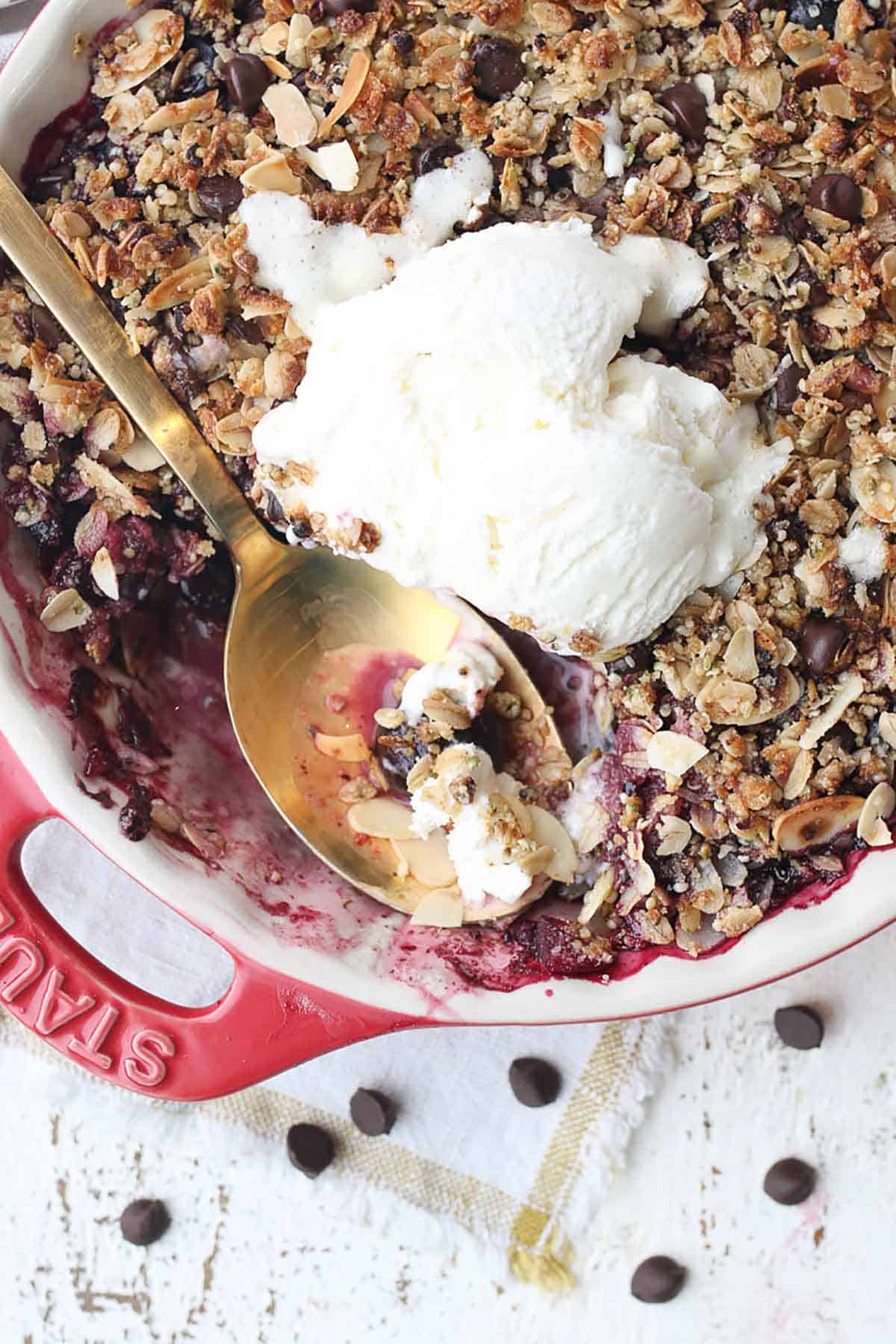 Close up of gluten free cherry crisp topped with ice cream. 