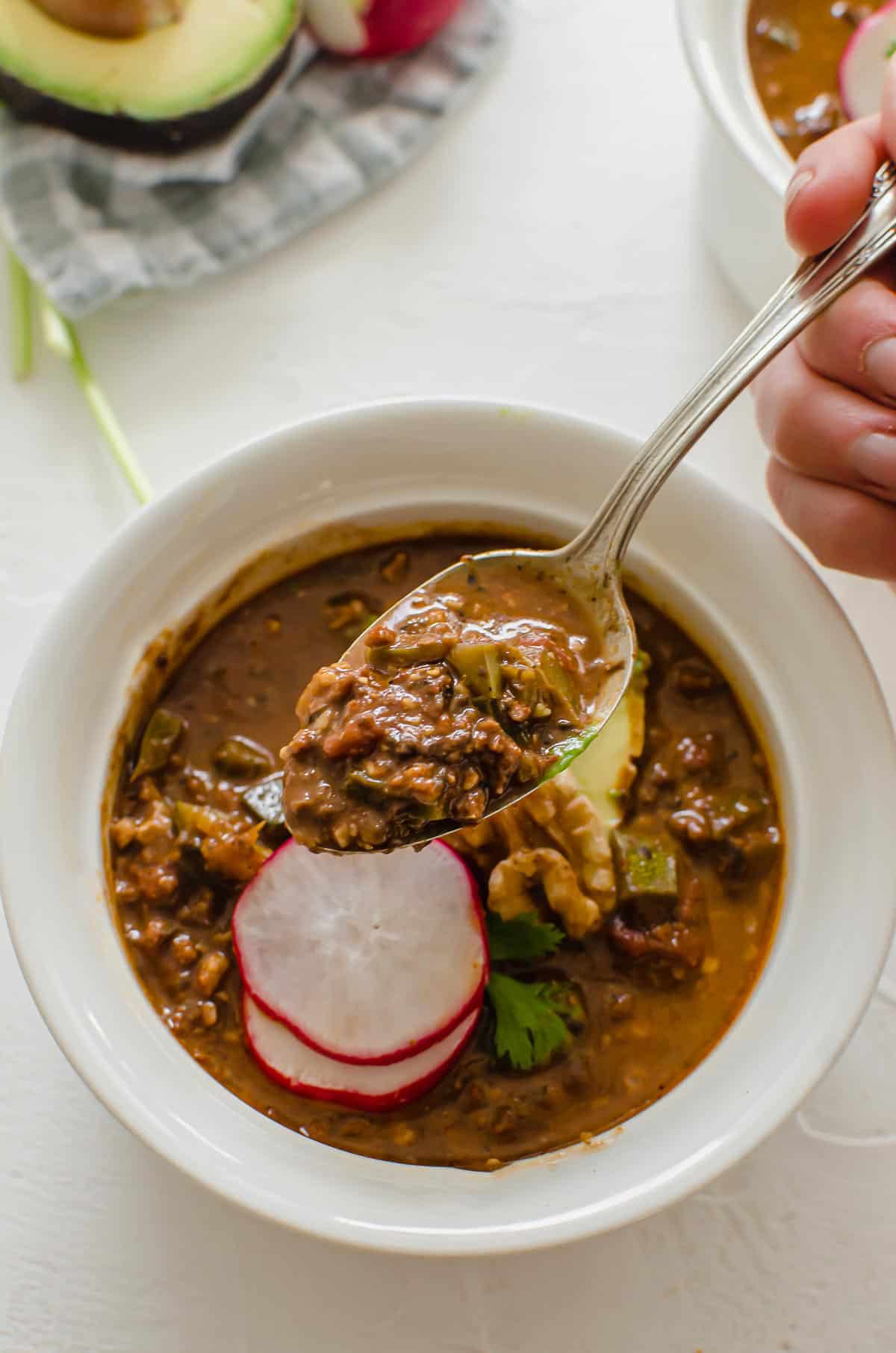 Close up image of a spoon filled with chili.