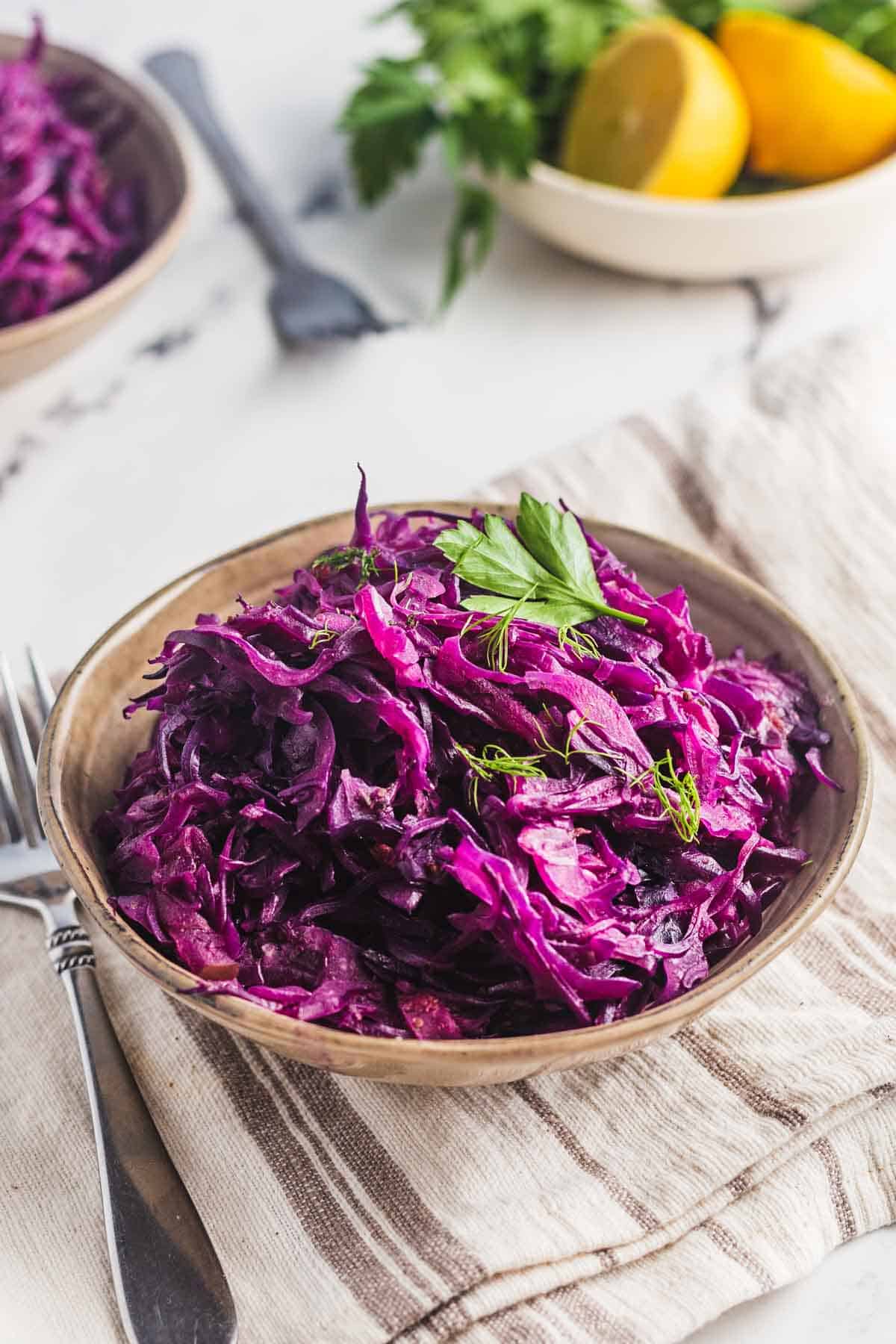 Instant pot cabbage in a bowl and garnished with dill and cilantro. 