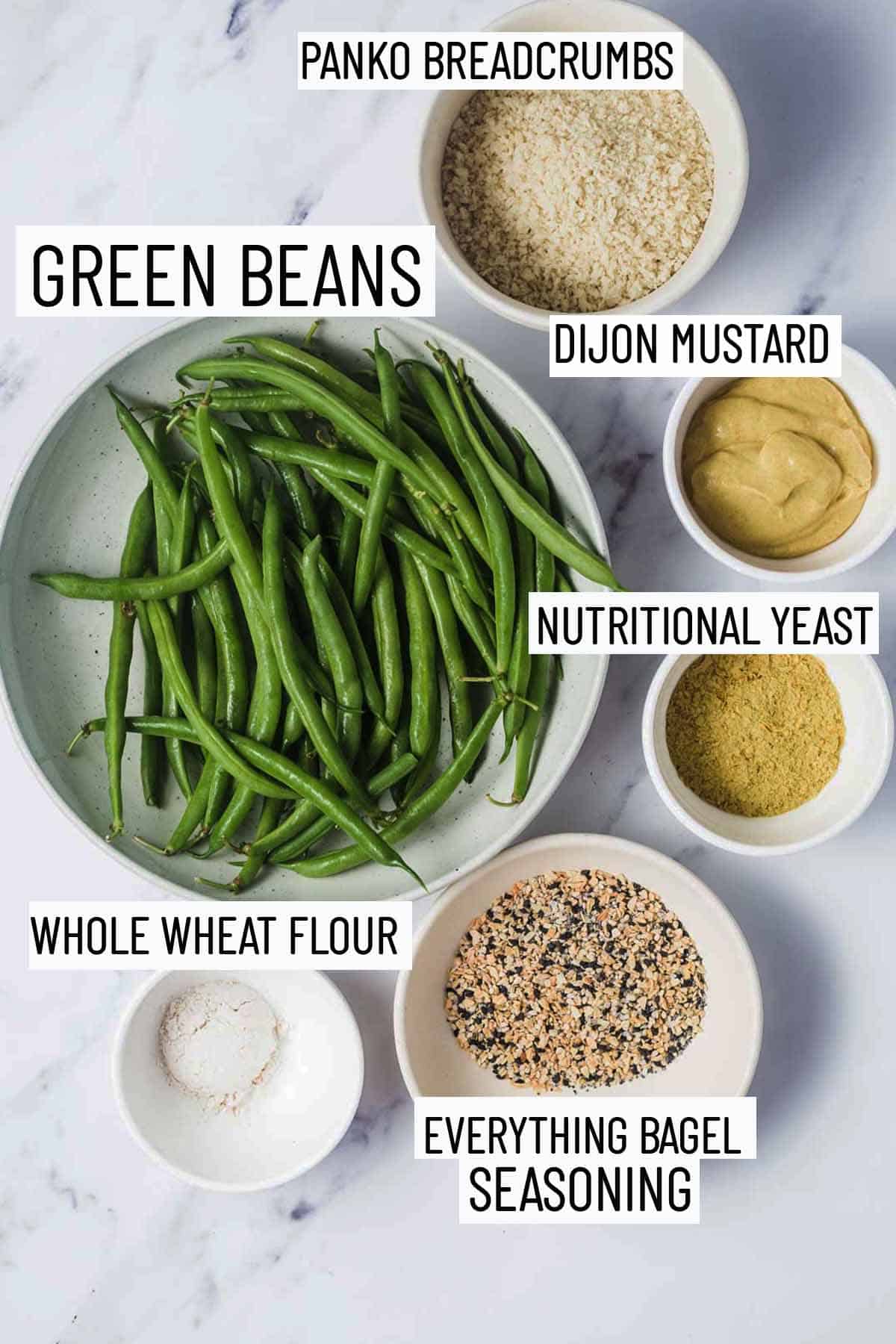 Flat lay image of portioned recipe ingredients including green beans, panko breadcrumbs, dijon mustard, nutritional yeast, everything bagel seasoning, and whole wheat flour. 