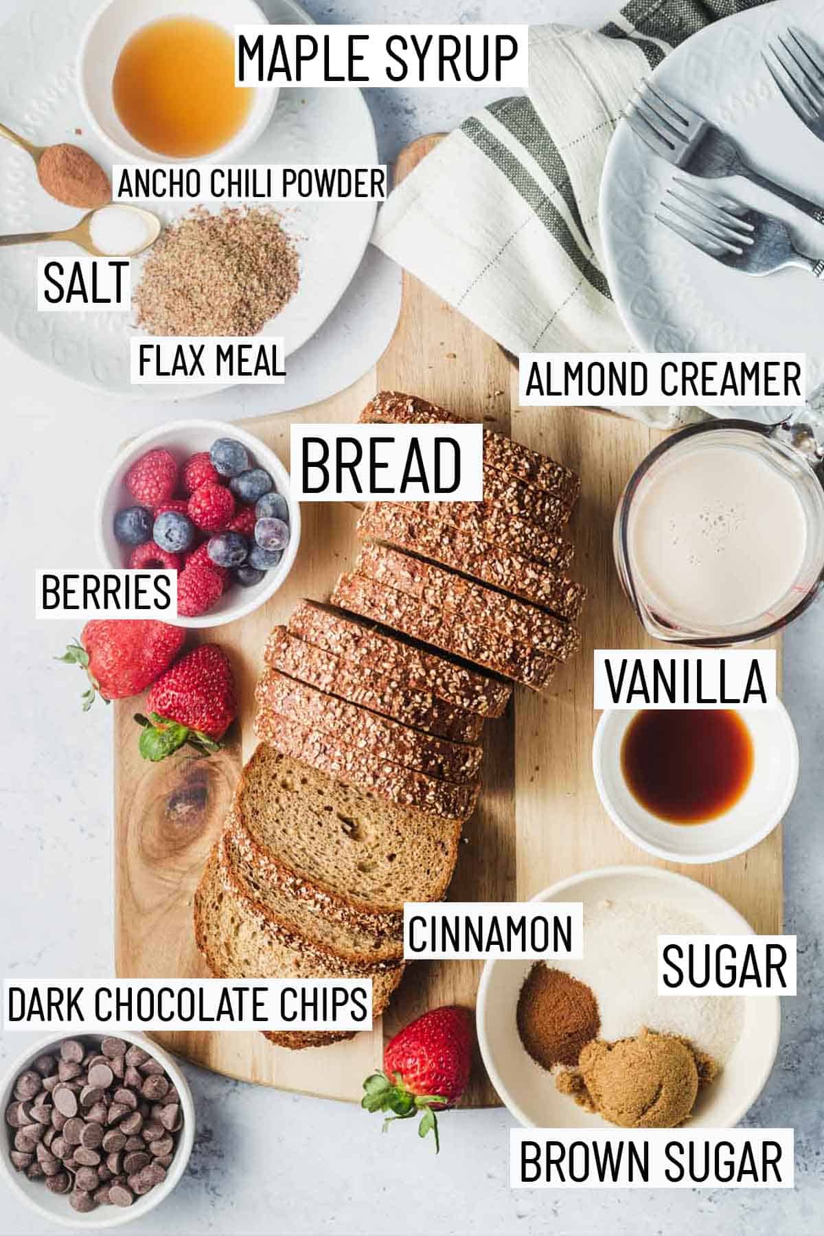 Flat lay image of portioned ingredients including sugar, vanilla, almond creamer, dark chocolate, bread, berries, flax seed, salt, ancho chili powder, maple syrup.