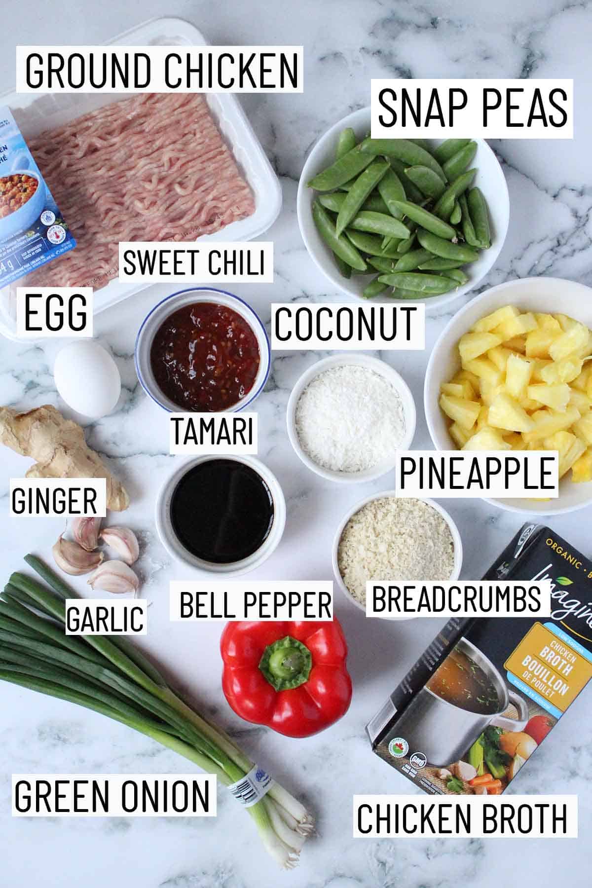 Flat lay image of portioned hawaiian meatballs recipe ingredients including snap peas, ground chicken, sweet chili sauce, coconut, pineapple, tamari, egg, ginger, garlic, breadcrumbs, broth, bell pepper, and green onion. 