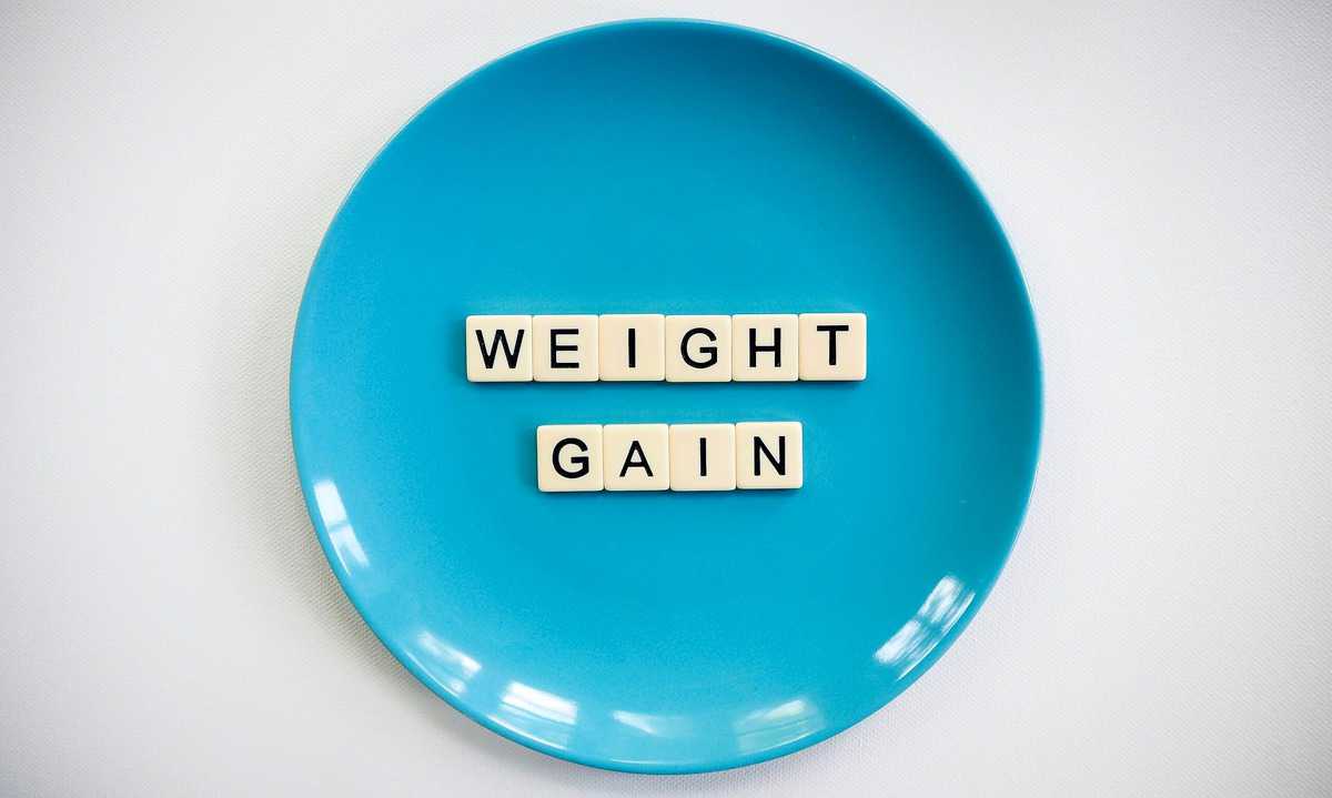 A blue plate with the words "weight gain" written in tiles. 