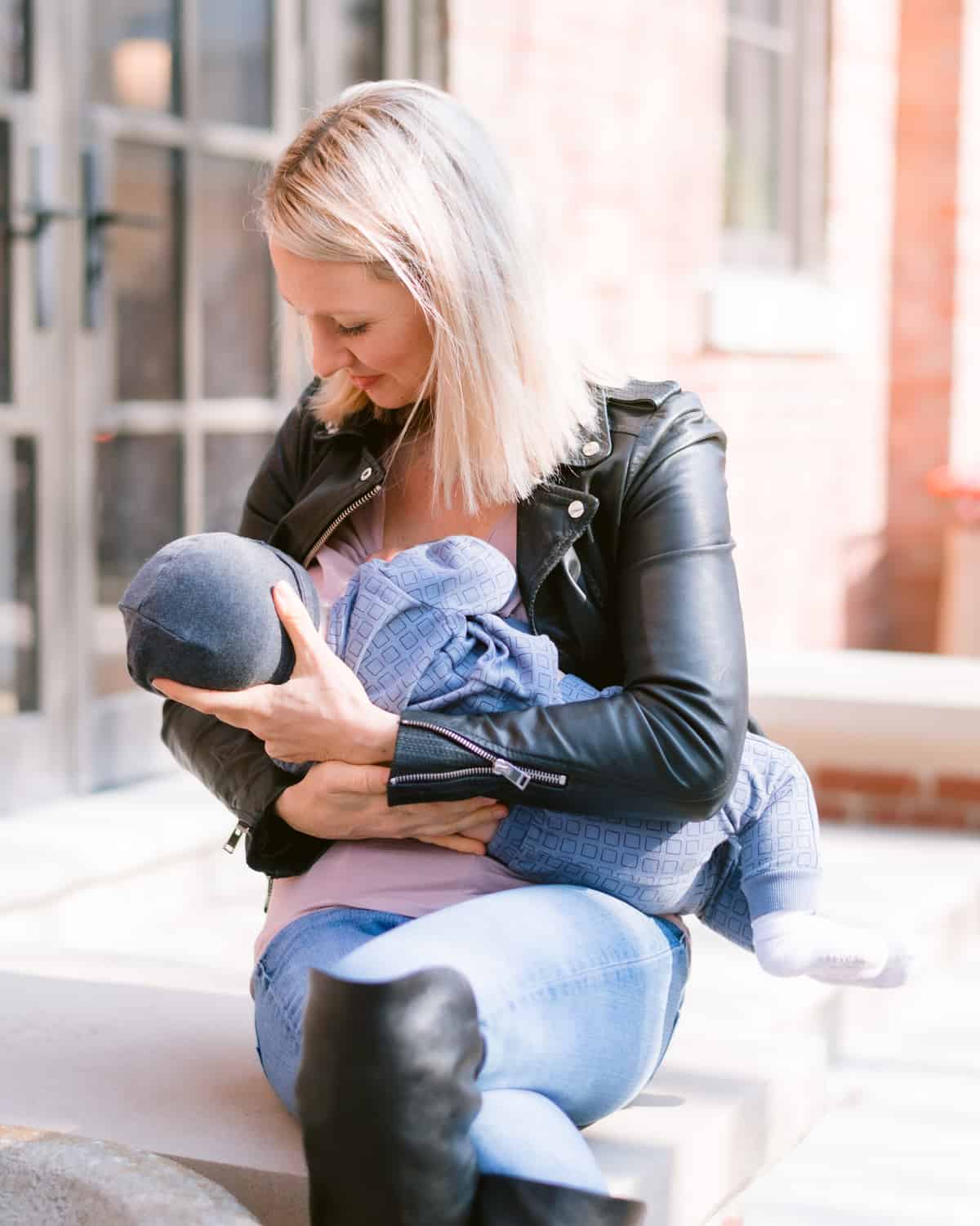 Abbey holding her breastfed baby while sitting outside.