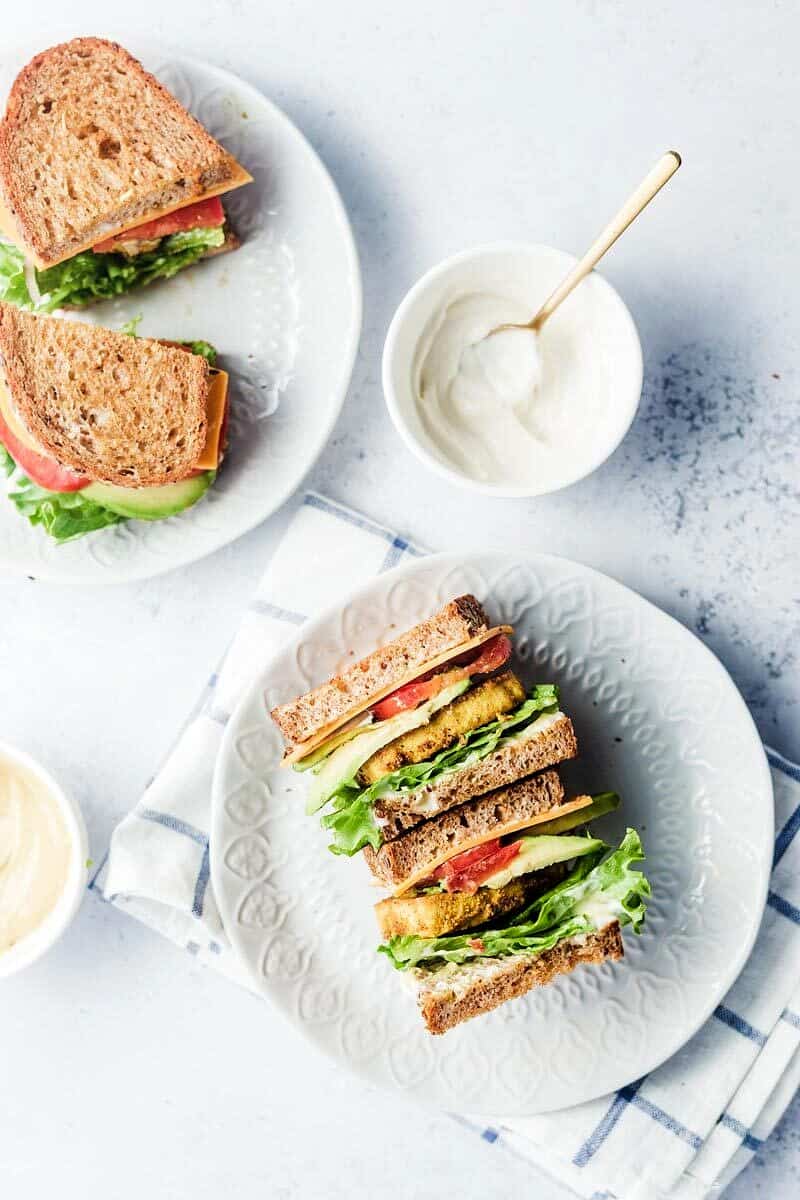 Birds eye view of tofu breakfast sandwich on a white plate. 