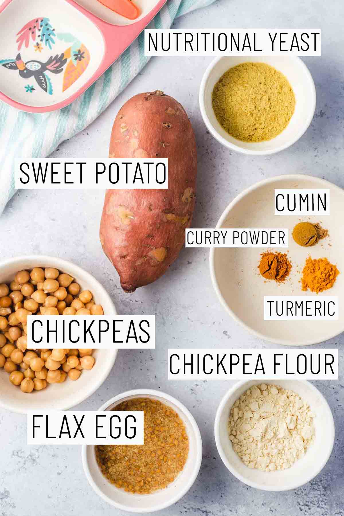 Flay lat image of portioned recipe ingredients including sweet potato, nutritional yeast, chickpeas, turmeric, cumin, curry powder, chickpea flower, and flax egg.