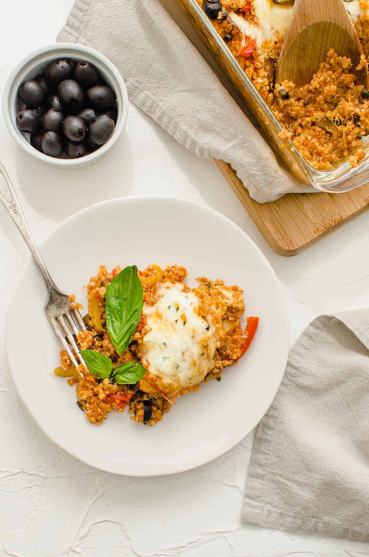 Birds eye view image of plated pizza quinoa casserole garnished with basil. 