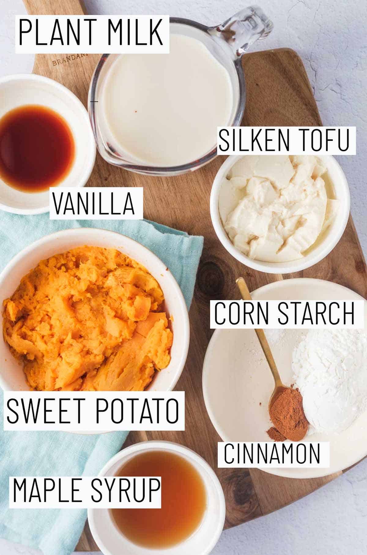 Flat lay image of portioned recipe ingredients including maple syrup, cinnamon, cornstarch, sweet potato, tofu, milk, and vanilla. 