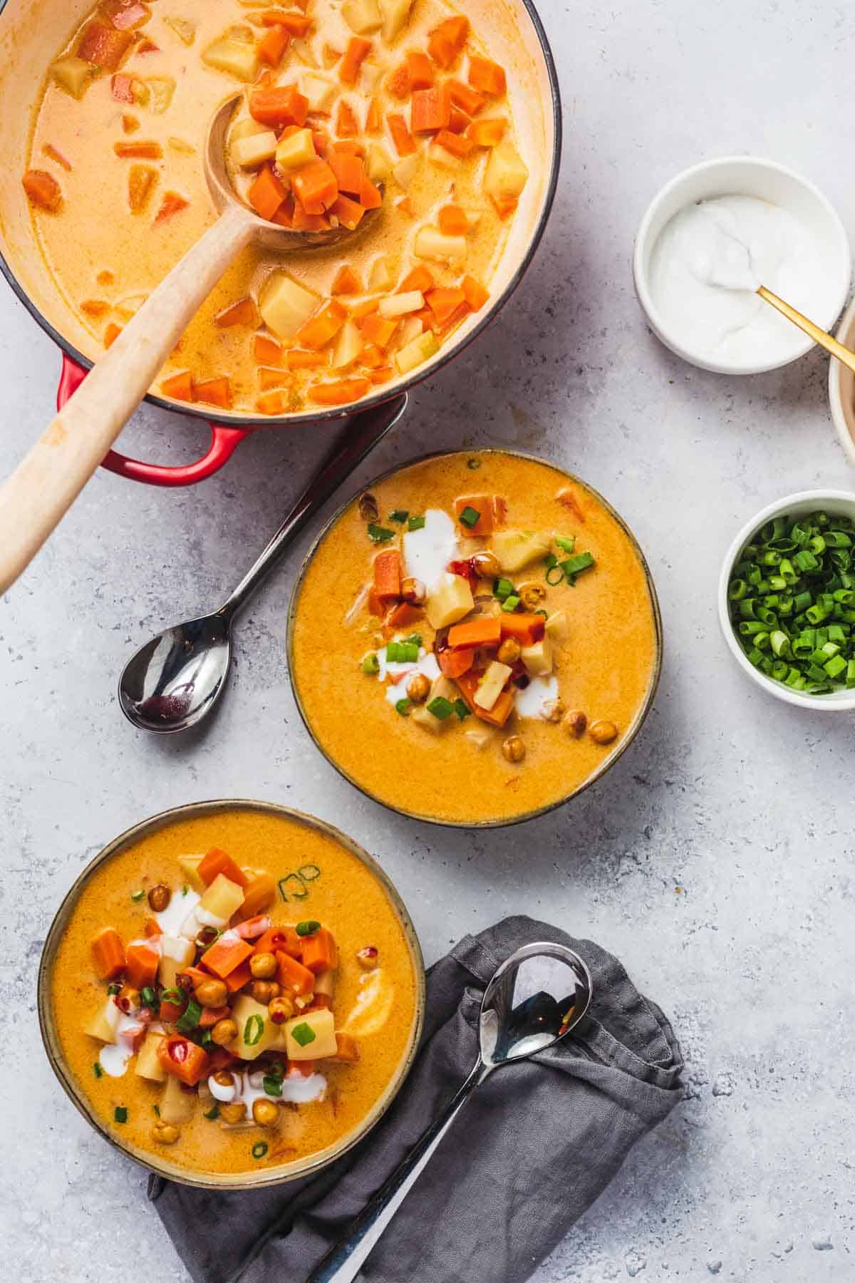 Birds eye view image of two bowls of Gochujang soup topped with scallions.
