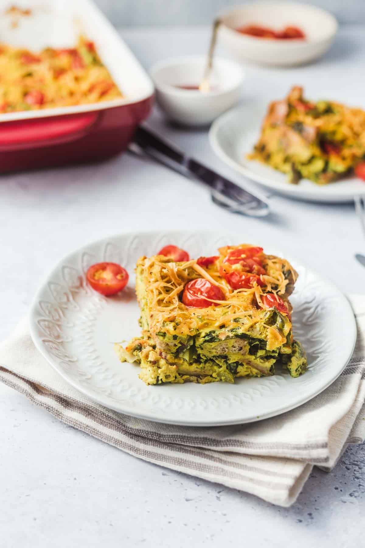 Close up a piece of vegan strata on a white plate.