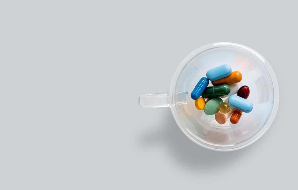 Birds eye view of several supplements in a clear mug.
