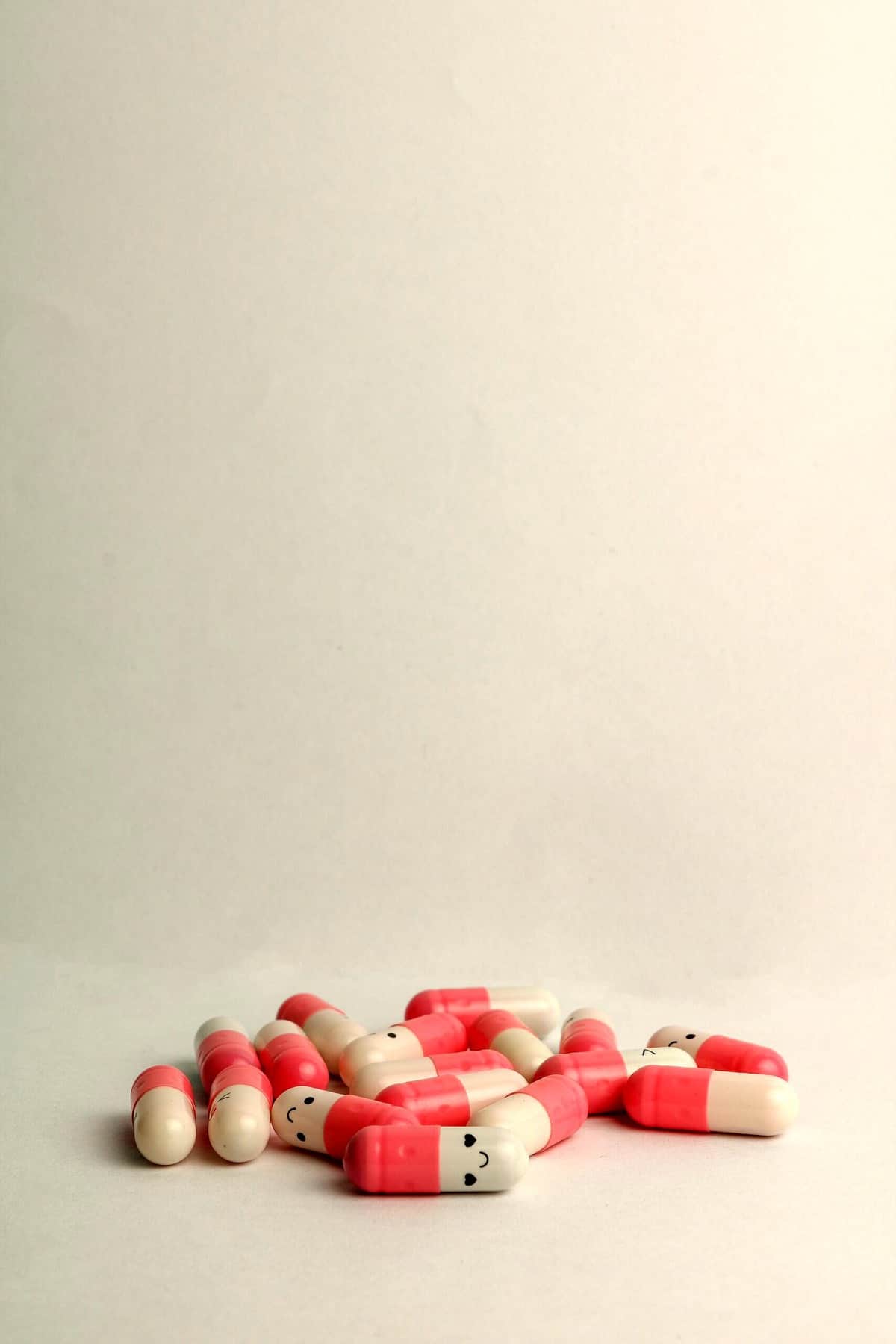 Several supplements with smiley faces on a white surface.