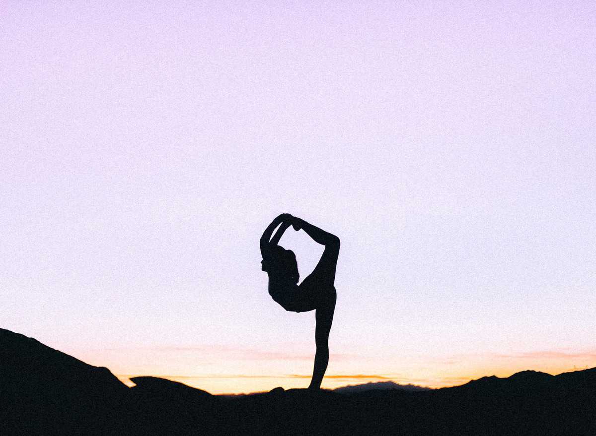 A woman doing yoga outside. 