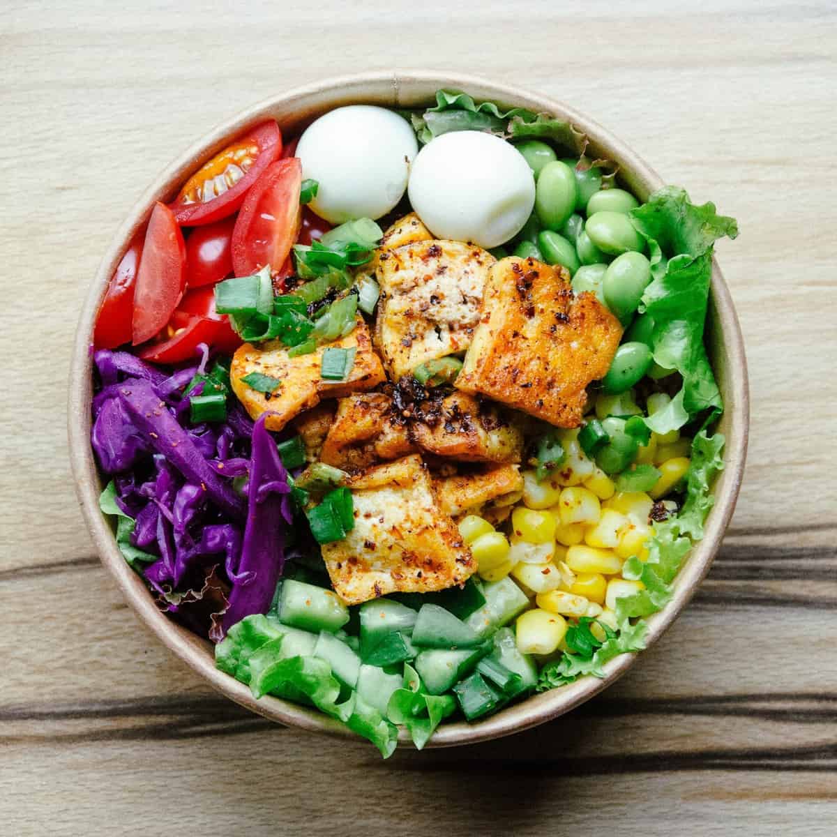 A birds eye view of a veggie bowlwith tofu. 