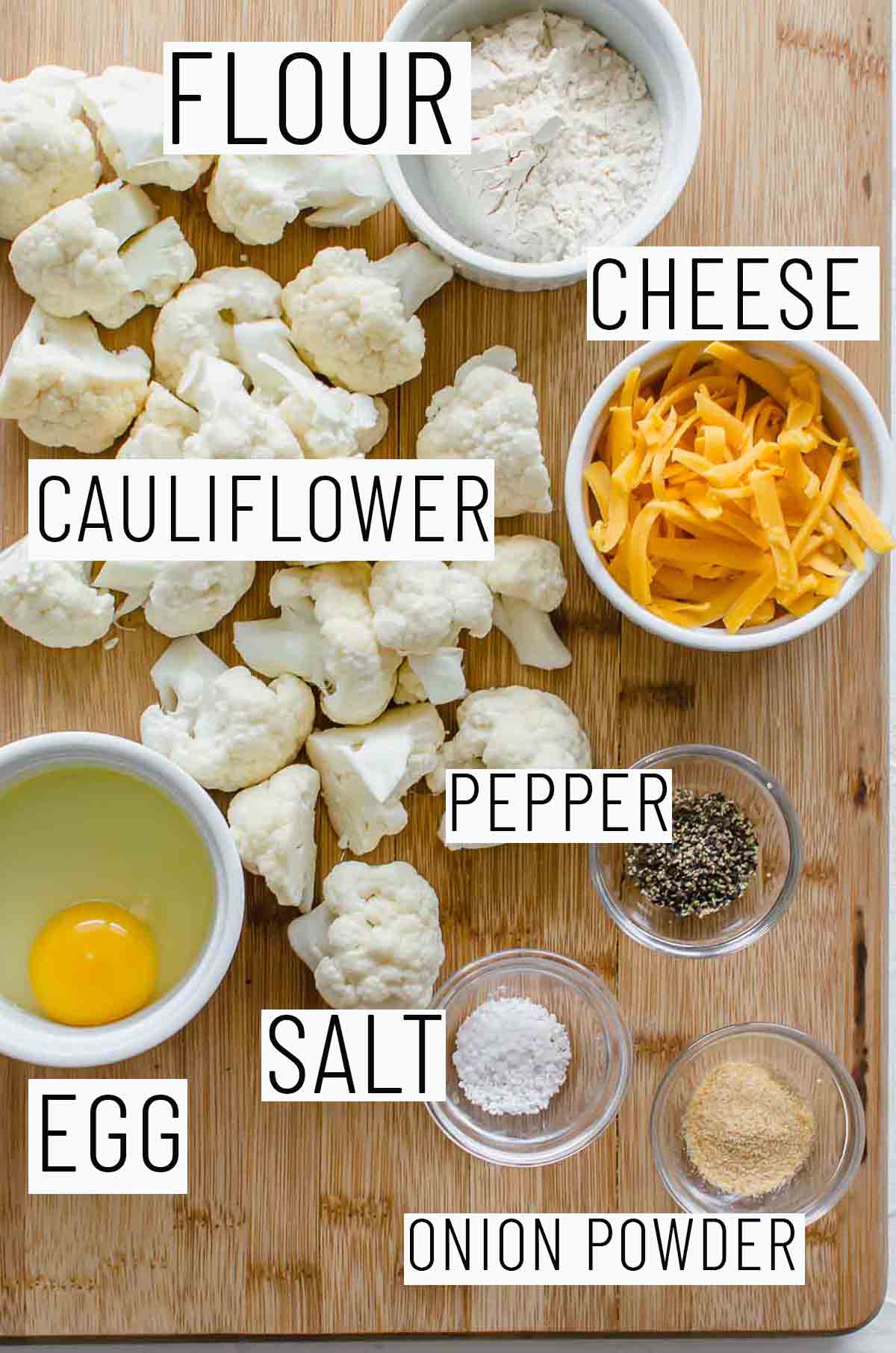 Flat lay image of recipe portioned ingredients including cauliflower, flour, egg, cheese, and seasonings. 