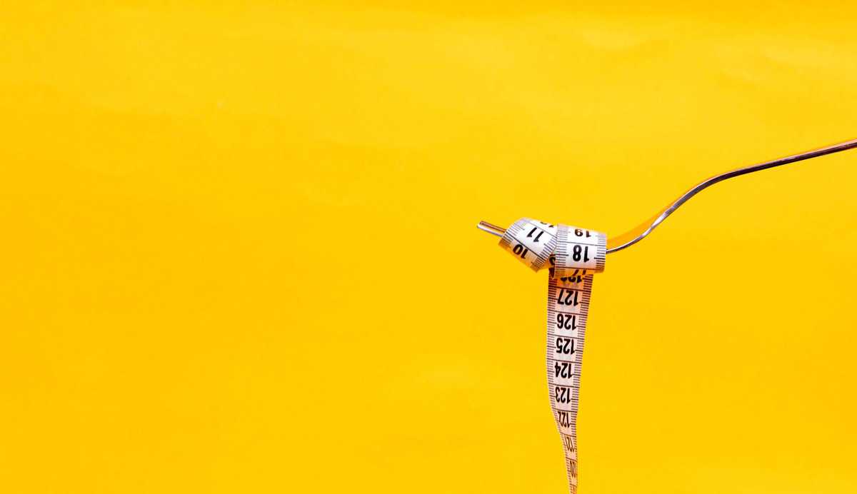 A measuring tape wrapped around a fork. 