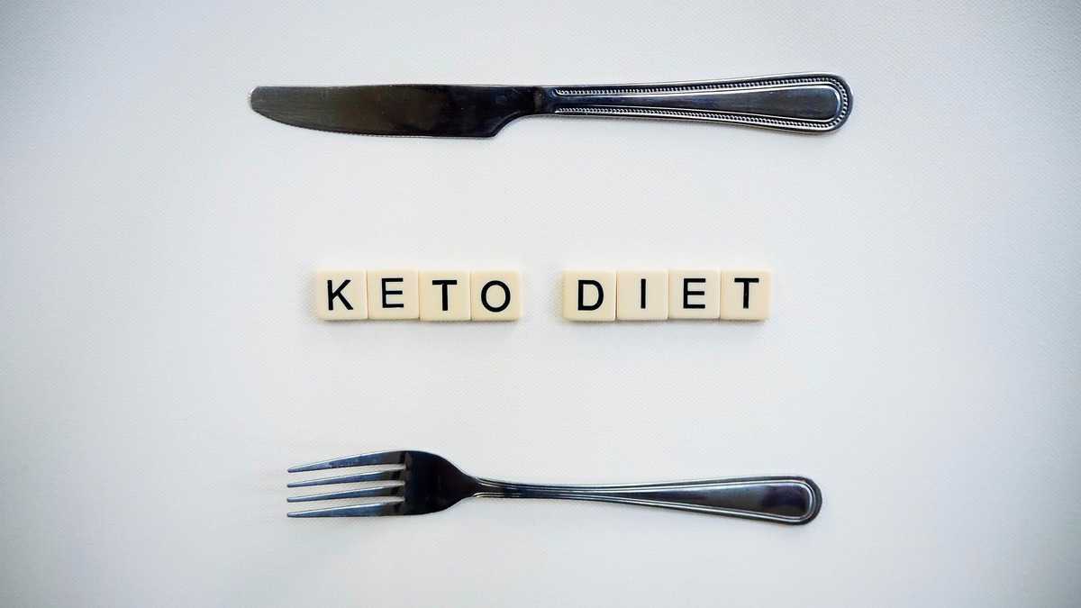 The letters "keto diet" spelled out in tiles with two forks on the top and bottom. 