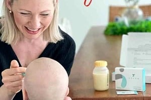 Pinterest graphic of abby feeding a baby with text overlay "how the gut microbiome helps build baby's immune system."