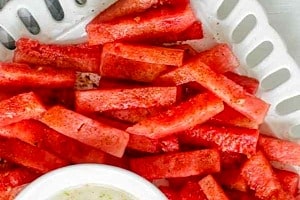 Pinterest graphic of a platter of watermelon sticks and dip.