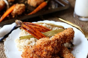 Pinterest graphic of a plate of buffalo chicken strips with grains, carrots, and celery.