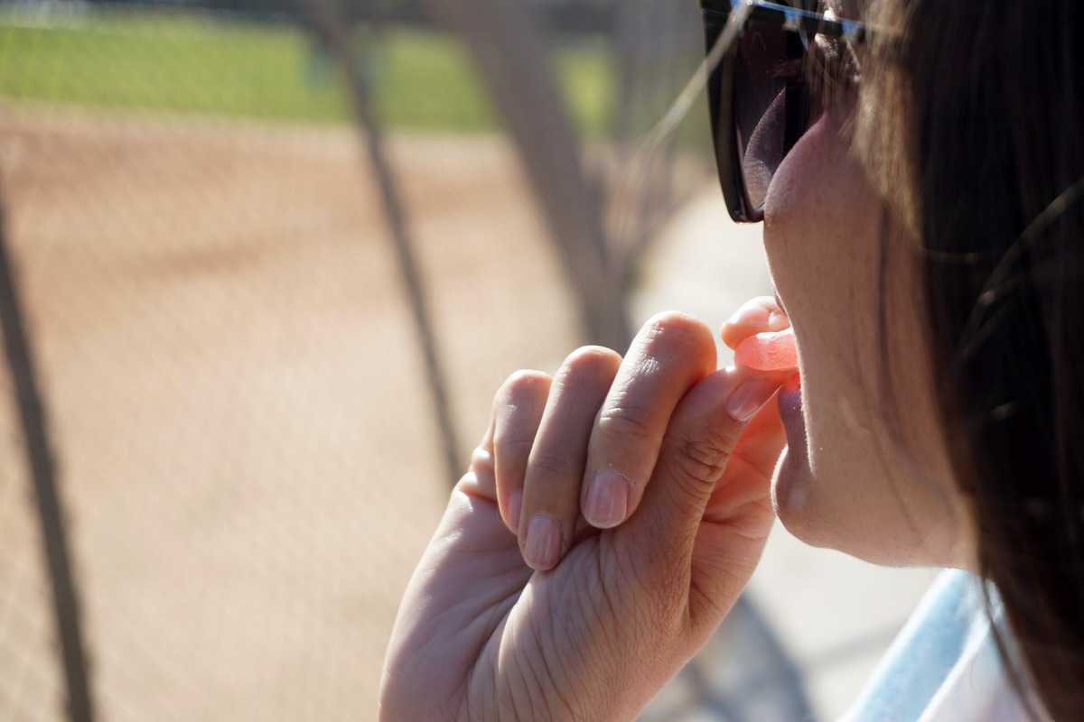 A woman taking sugar bear hair gummies.