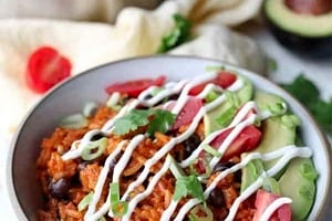 Pinterest graphic of an enchilada bowl with sour cream and garnishes.