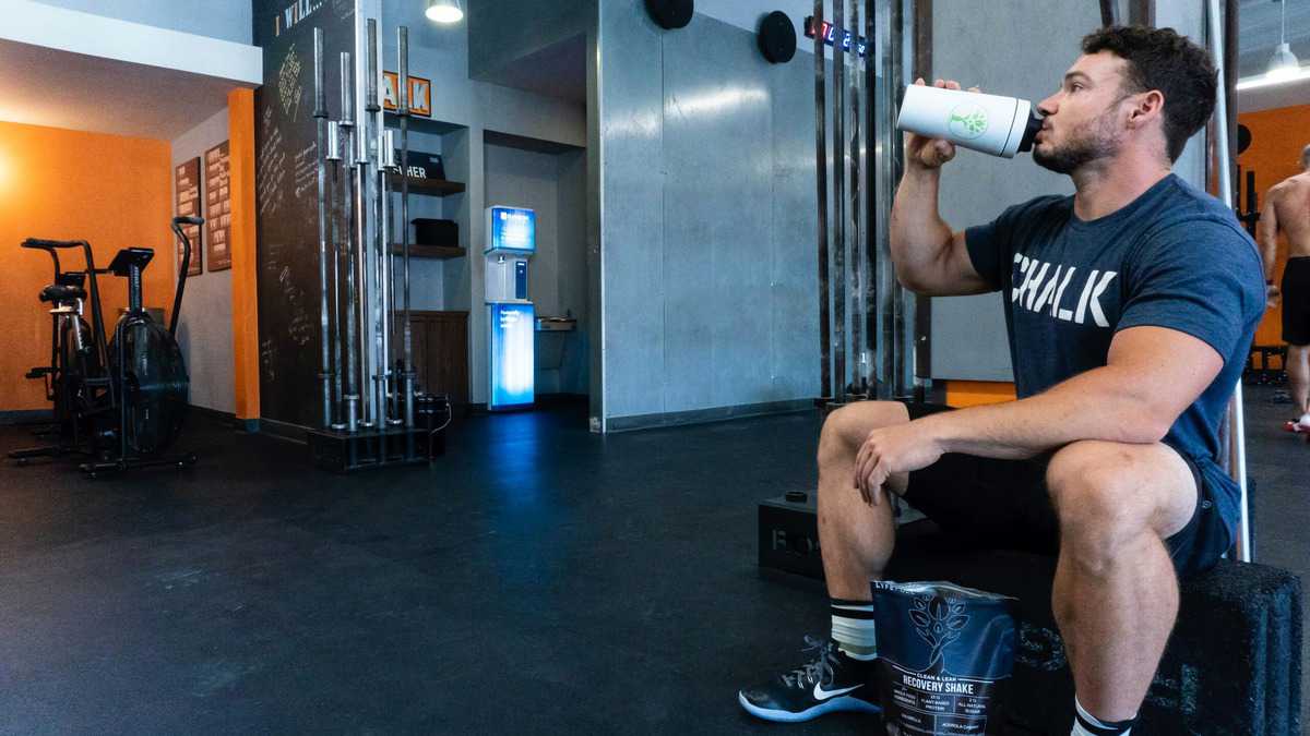 A man drinking from his protein shake.
