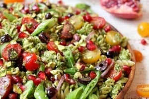 Pinterest graphic an angled view of a plate of pesto pasta salad.