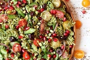 Pinterest graphic of a bowl of pasta with text overlay "pesto pasta salad, vegan-friendly."