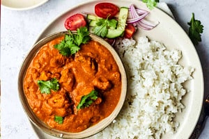 Pinterest graphic of the overhead view of a bowl of butter chicken with tofu and a side of rice.