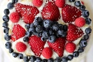 Pinterest graphic of the overhead view of a watermelon cake with fruit on top with the text overlay "easy vegan dessert watermelon cake."