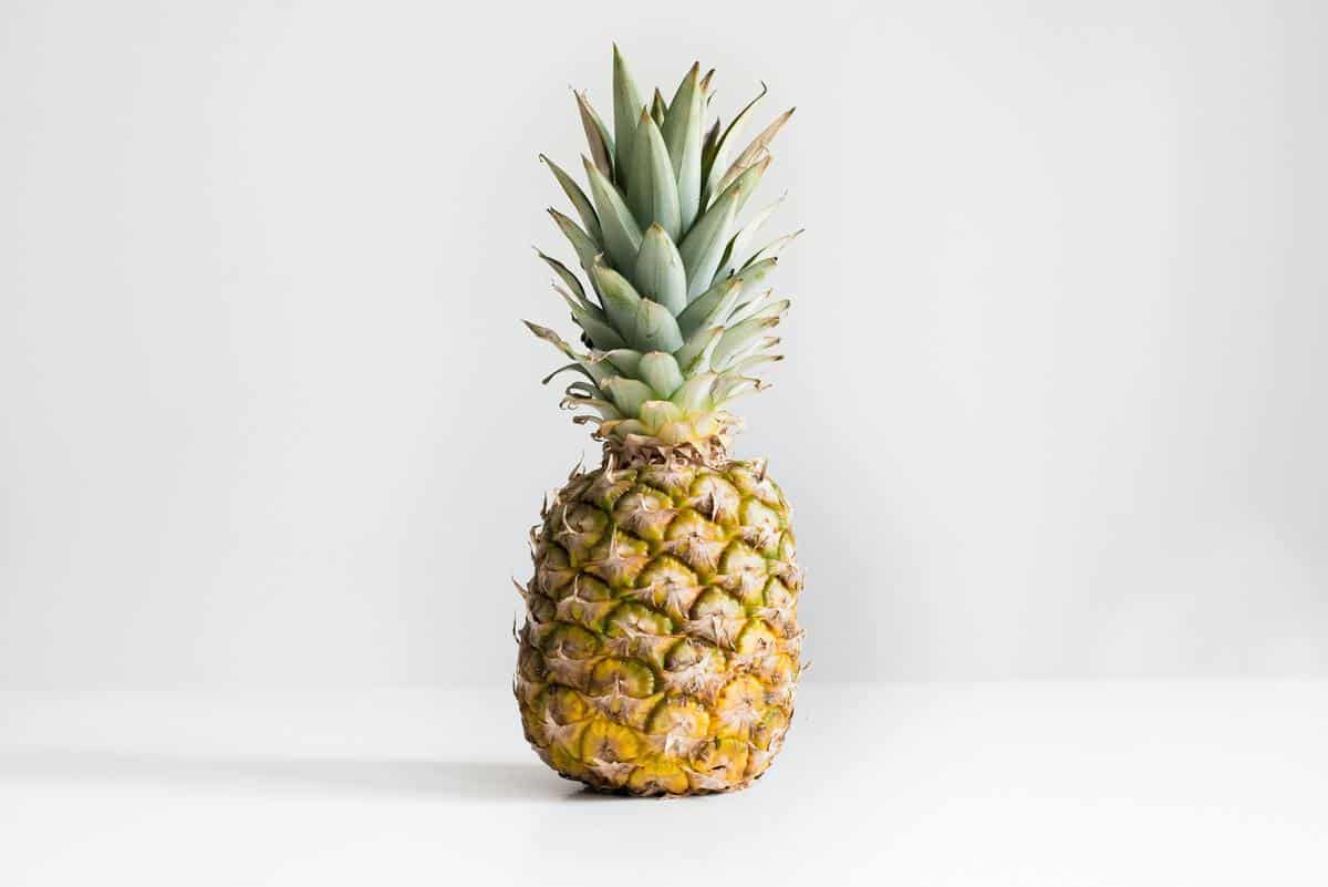 A pineapple on a white counter.