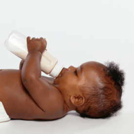 Baby laying down with bottle.