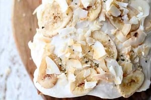 Pinterest graphic of the overhead view of a vegan cake with the text overlay "Banana Carrot Cake with Cream Cheese Frosting."