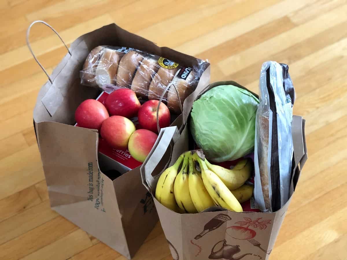 Two grocery bags full of fresh food.