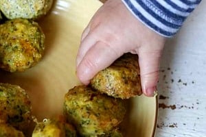 A toddler hand reaching for mini muffins.
