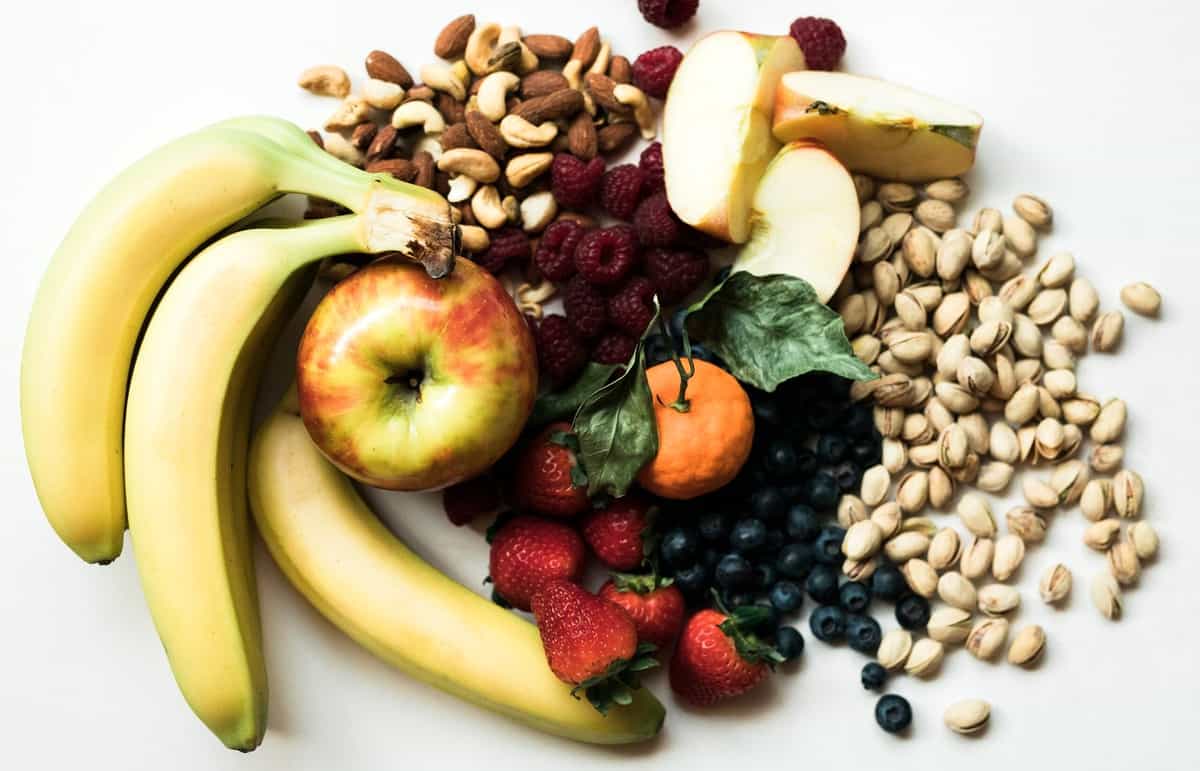 A spread of healthy snacks like bananas, apples, cashews, pistachios, and more.