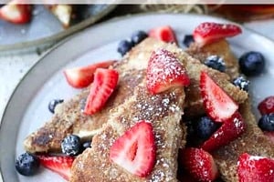 Pinterest graphic of a stack of berry topped toast with the text overlay "low carb french toast."