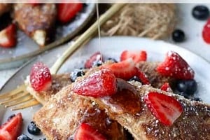 Pinterest graphic of syrup being poured onto a stack of low carb french toast with berries and the overlay text "vegan, gluten free, lc french toast."