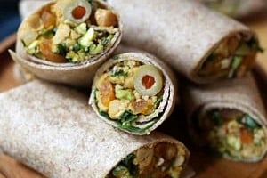 Pinterest graphic of a plate with multiple wraps with the text overlay "vegan Moroccan chickpea wrap."