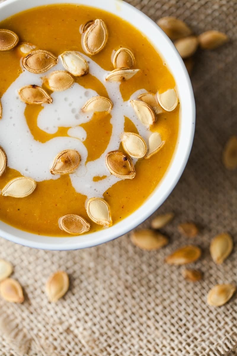 Pumpkin soup with pumpkin seeds on top.