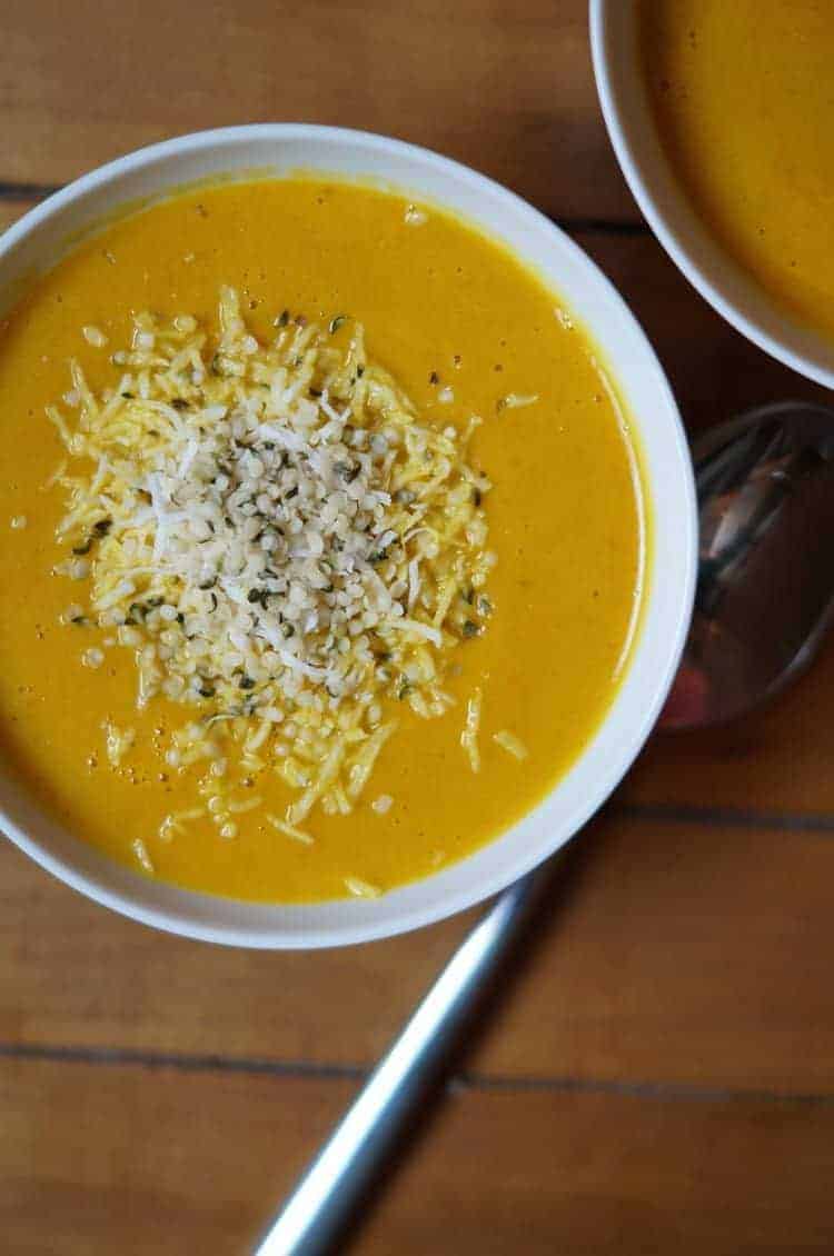 Bowl of pumpkin soup topped with hemp hearts.