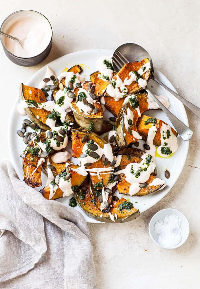 Plate of roasted pumpkin with chilli yogurt and coriander sauce.