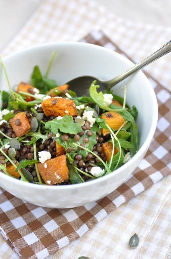 Bowl of pumpkin lentil salad with arugula and feta.