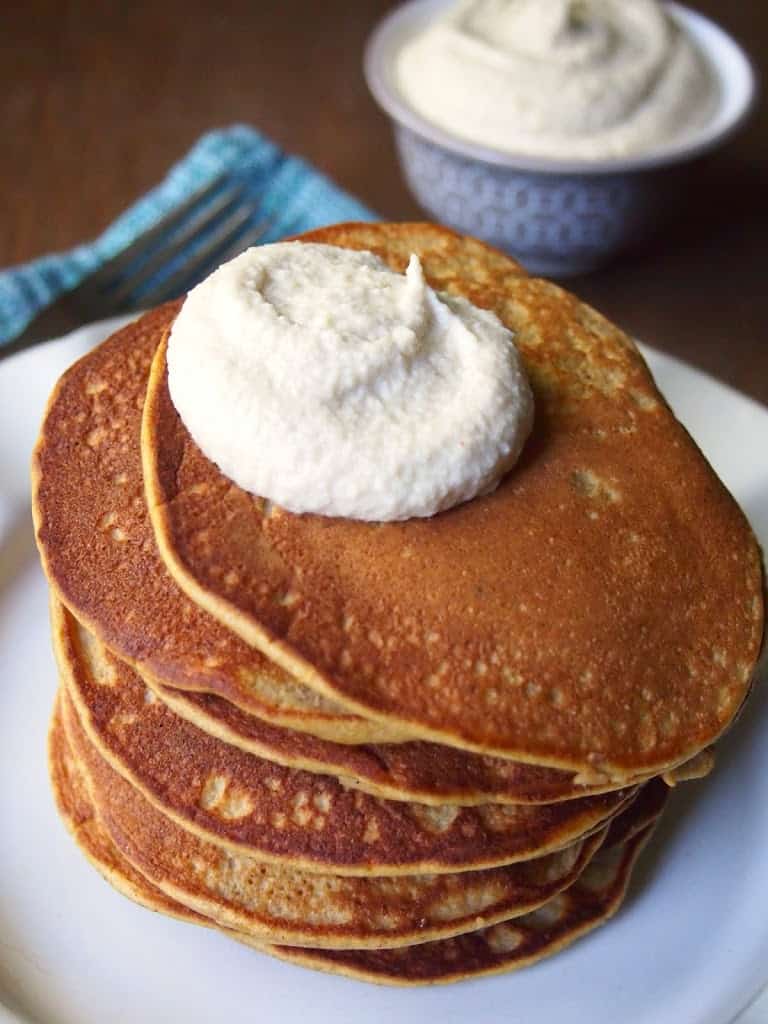 Stack of paleo pumpkin pancakes with maple cashew cream.