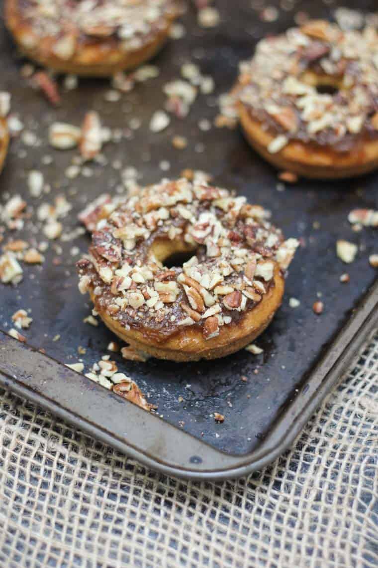 Close up of pecan pumpkin pie donut topped with crushed pecans.